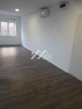 Empty room with white walls, dark laminate flooring, and an air conditioning unit. - image 3