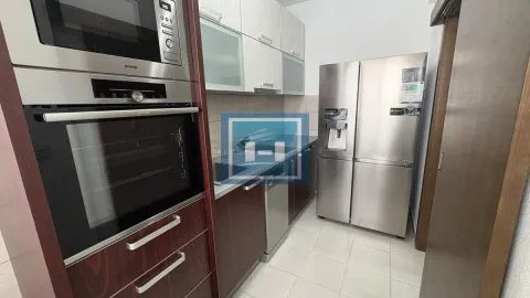 Compact equipped kitchen with a built-in oven, microwave, and large refrigerator. - image 9