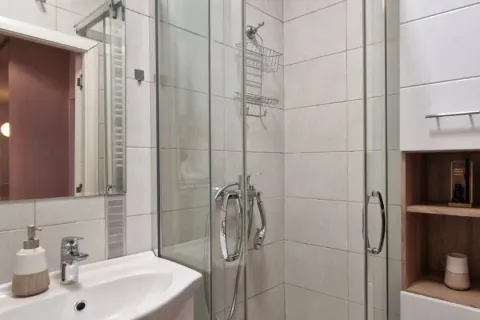 Bathroom equipped with a washbasin and a glass shower enclosure. - image 2