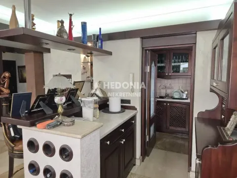Tradicionalno opremljena kuhinja sa tamnim drvenim elementima i šankom. - image 7