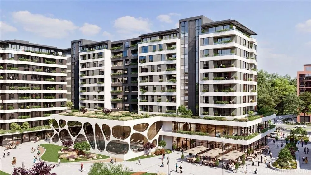 Exterior view of a modern residential building with a landscaped plateau and ground floor commercial spaces.