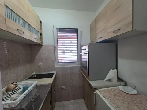 Small kitchen with wooden cabinetry and a window. - image 9