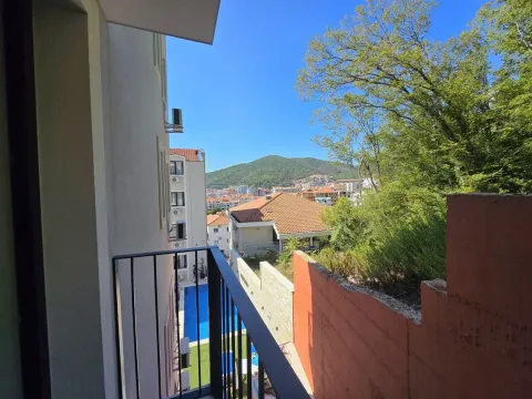 Pogled sa balkona na okolne zgrade, brda i dio dvorišta sa bazenom. - image 7
