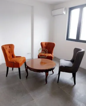 Living room with a round coffee table and armchairs. - image 4