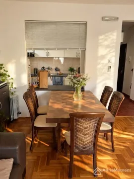 Dining area with a wooden table and chairs, overlooking the kitchen. - image 9