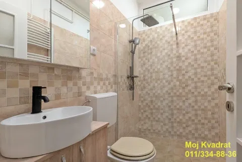 Kupatilo opremljeno umivaonikom, WC šoljom i tuš kabinom sa staklenim paravanom. - image 4