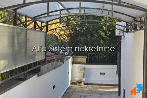 Covered walkway with a water fountain and a view of greenery. - image 26