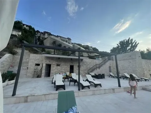 Prostrano popločano dvorište sa ležaljkama i modernom nadstrešnicom ispred kamene kuće. - image 33