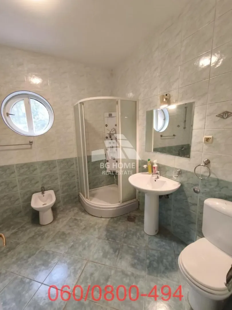 Kupatilo opremljeno tuš kabinom, umivaonikom i sanitarijama.