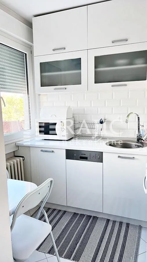 Small white kitchen with cabinets and a sink.