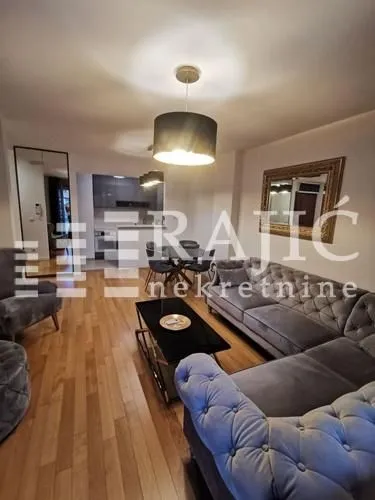 Spacious living room with a sofa set and dining area in the background.