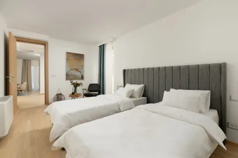 Svijetla spavaća soba sa dva singl kreveta i modernim uzglavljem. - image 9