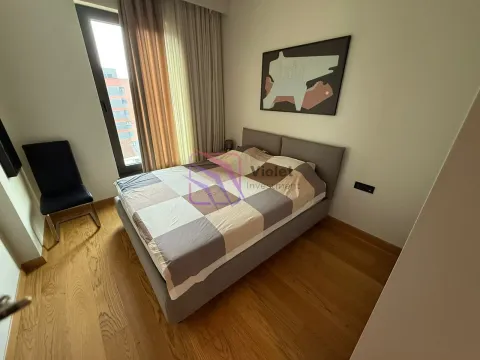 Spavaća soba sa bračnim krevetom, drvenim podom i velikim prozorom. - image 4