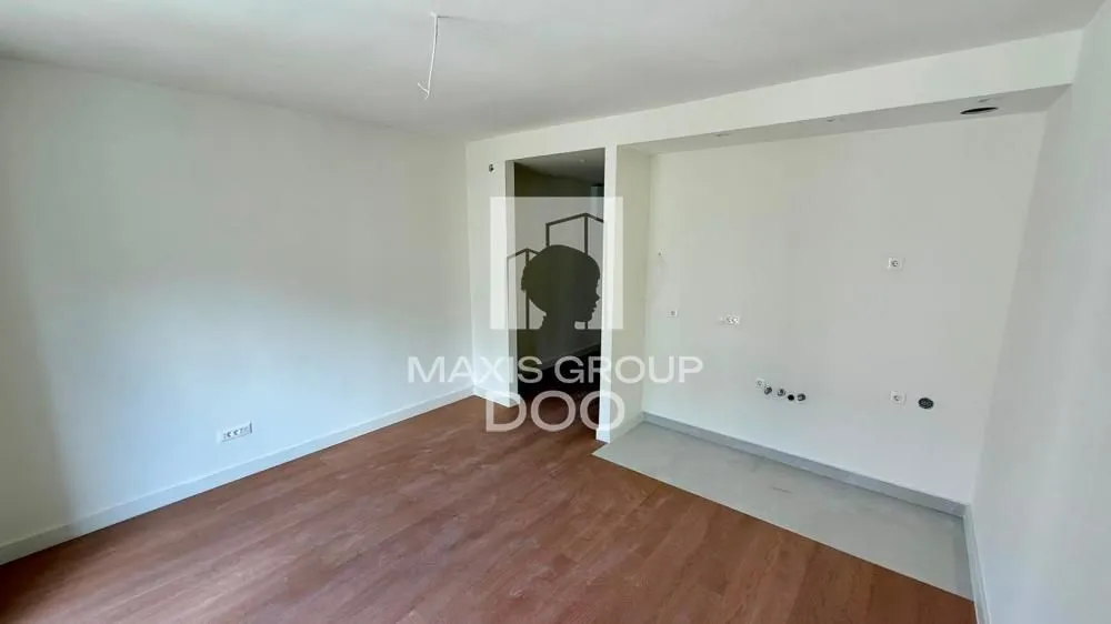 Empty room with wooden flooring and white walls.