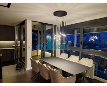 Dining area with a modern table, chairs, and chandelier as part of the living room. - image 10