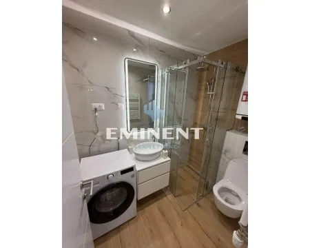 Modernly equipped bathroom with a walk-in shower and washing machine. - image 8