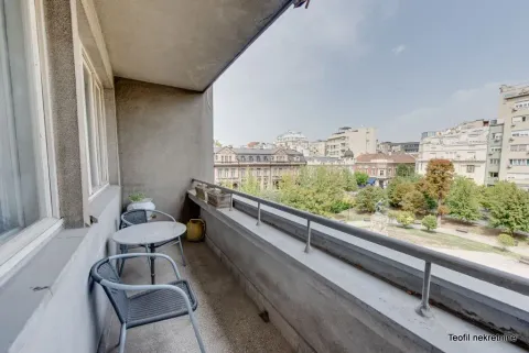 Natkriveni balkon sa stolom, stolicama i pogledom na park i grad. - image 19