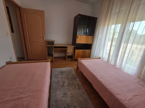 Spavaća soba sa dva kreveta i radnim stolom. - image 11