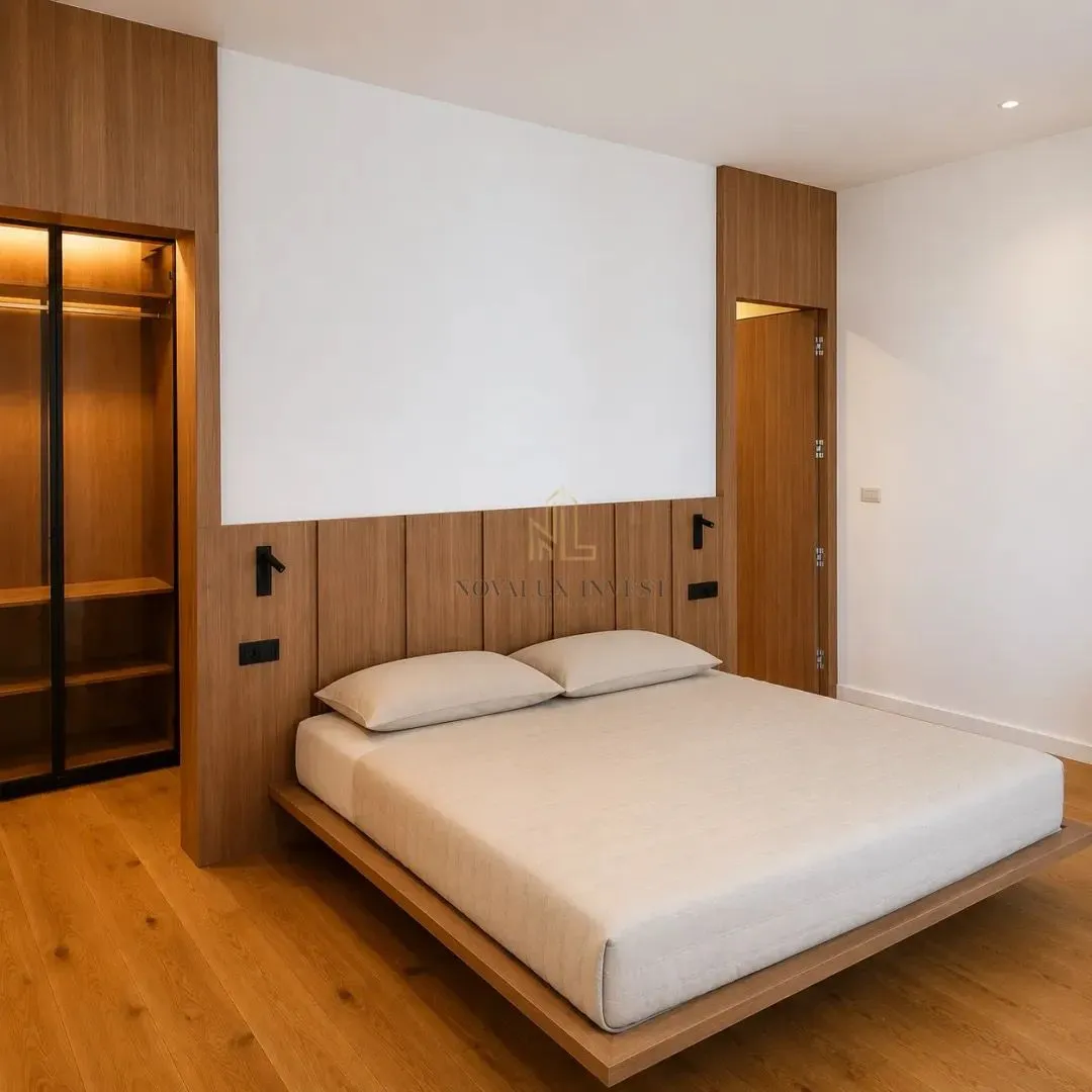 Modern bedroom featuring a double bed, wooden wall paneling, and a built-in wardrobe.