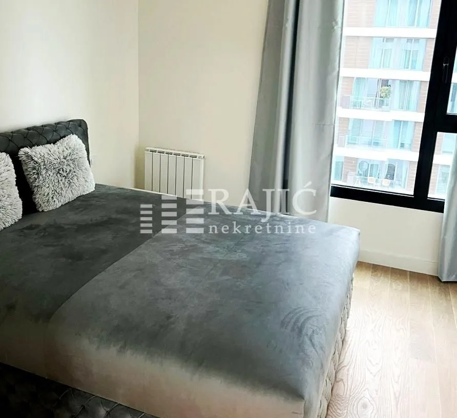 Furnished bedroom with a double bed and a window.