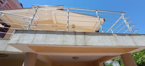 View of the exterior of the house with a terrace and metal railing. - image 14