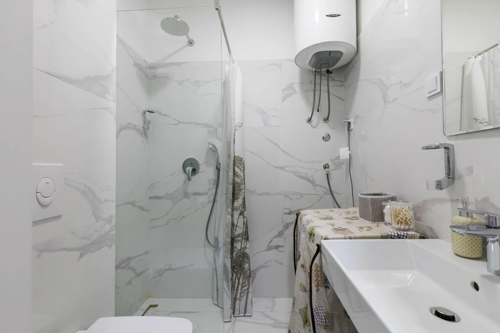 Modern bright bathroom with a shower cabin, washbasin, and water heater.