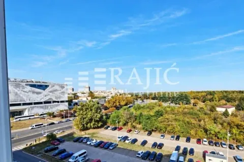 View from the apartment overlooking the city panorama and parking lot. - image 6