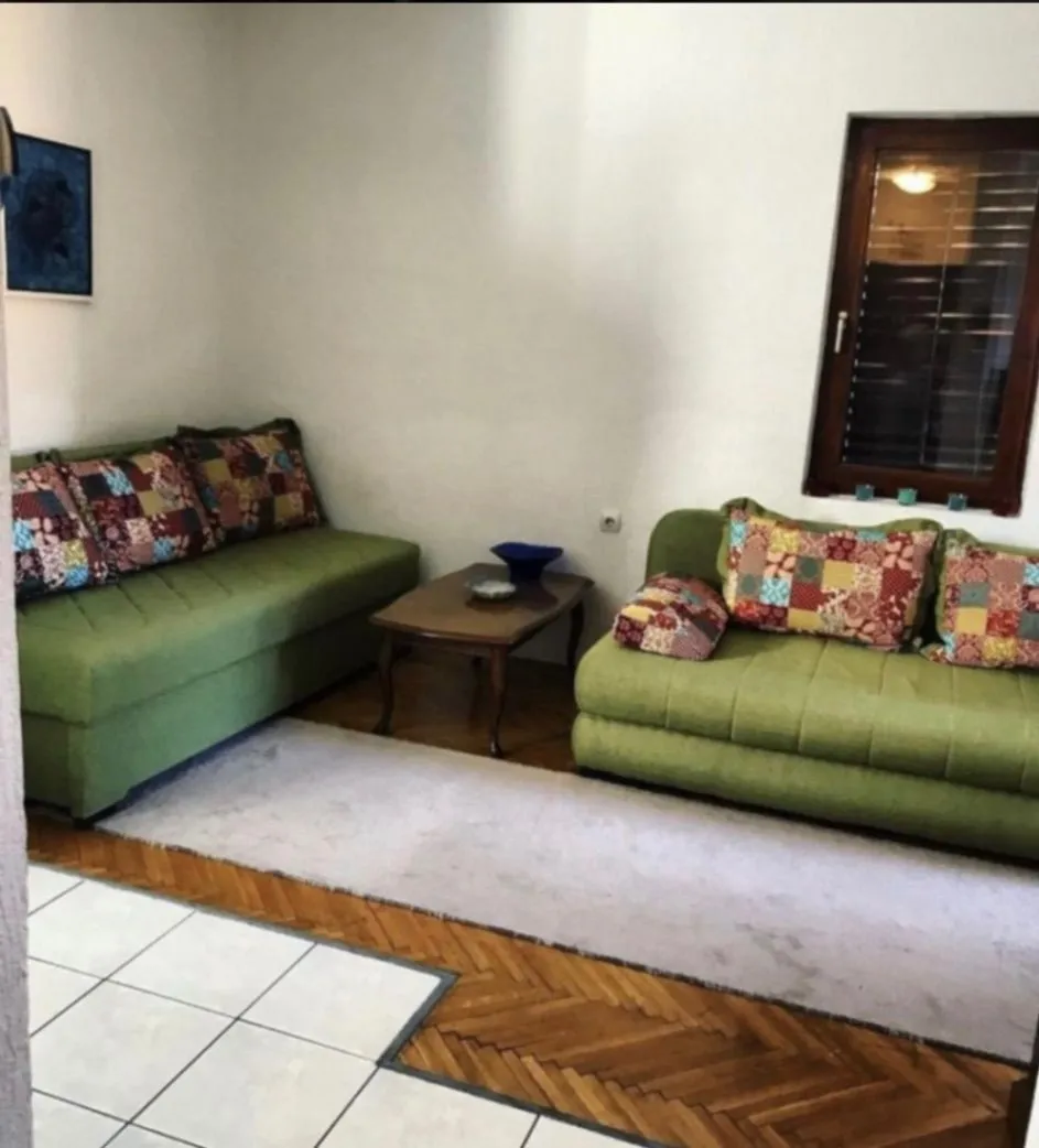 Living room with green sofas and a wooden coffee table.