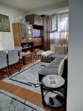 Living room with a sofa, wooden furniture, and dining table. - image 2