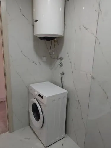 Part of a bathroom with a washing machine and water heater.