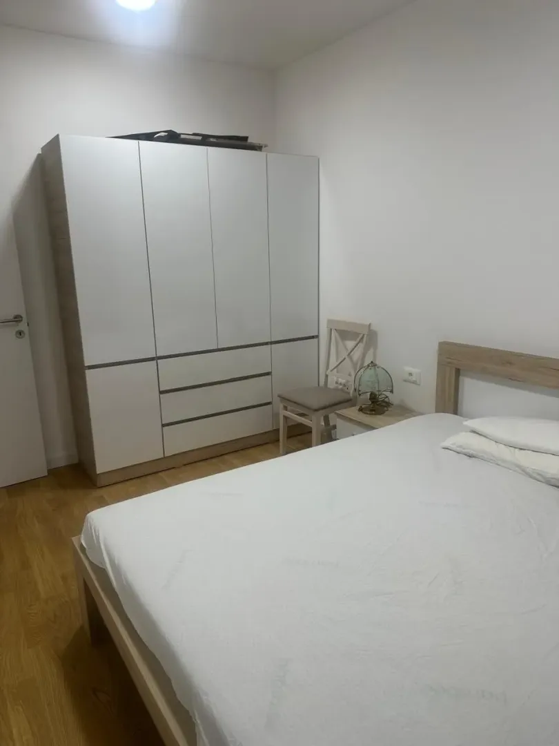 Furnished bedroom with a double bed and a large wardrobe.
