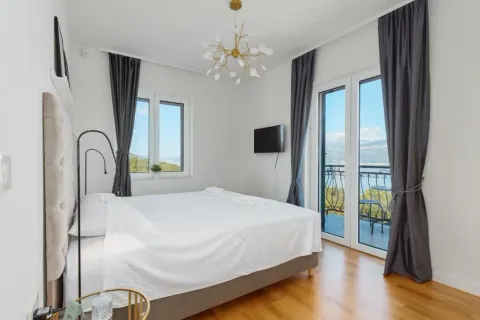 Bright bedroom with a double bed, balcony doors, and a sea view. - image 8