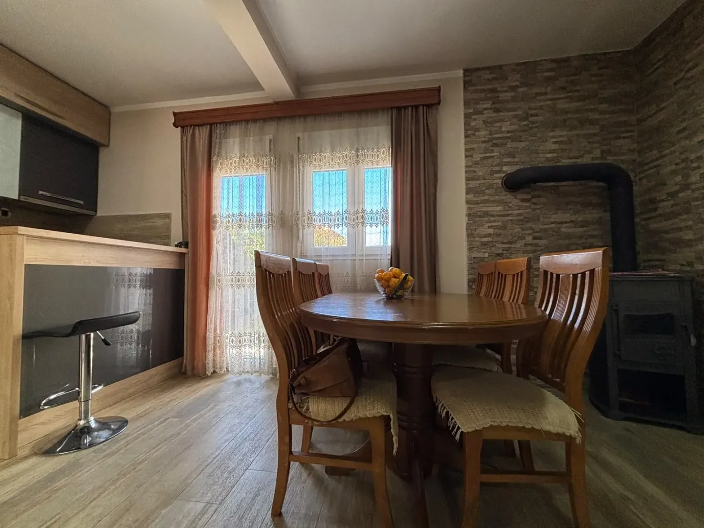 Living room with dining area, breakfast bar, and wood-burning stove.