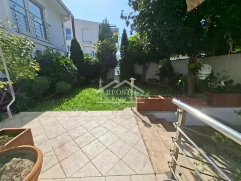 Dvorište kuće sa popločanom terasom i zelenom površinom. - image 15