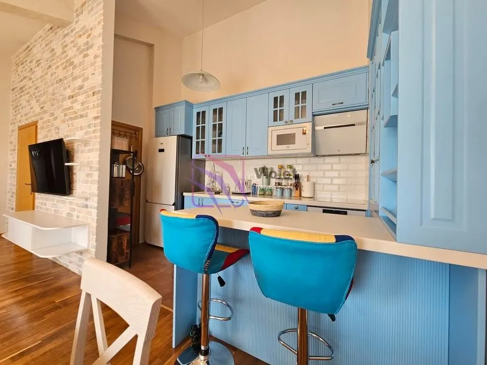 Kitchen with blue cabinets, a breakfast bar, and bar stools.