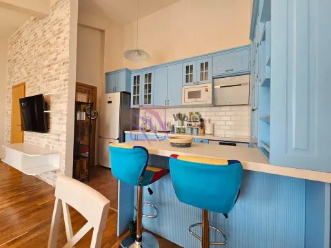 Kitchen with blue cabinets, a breakfast bar, and bar stools. - image 3