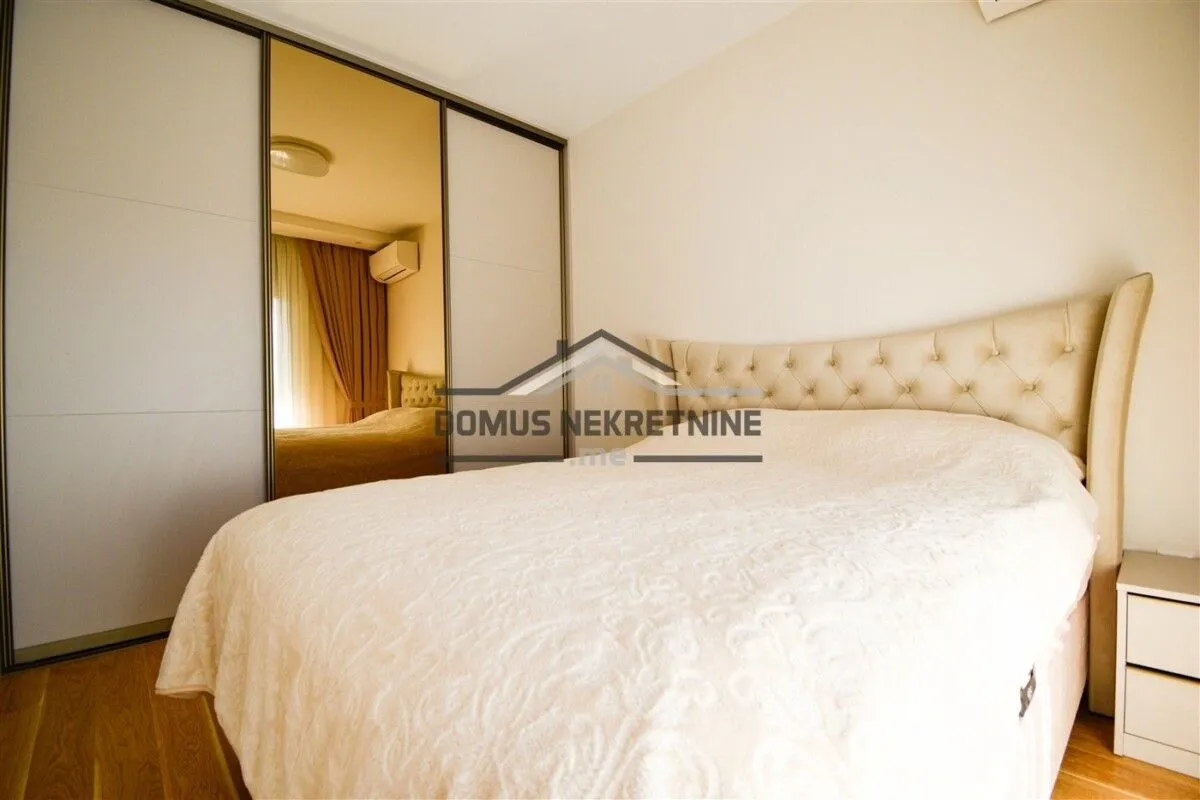 Furnished bedroom with a double bed and a fitted wardrobe with a mirror.