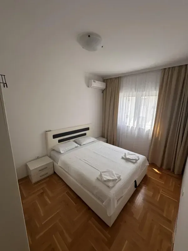 Bedroom with a double bed, bedside tables, and an air conditioner.