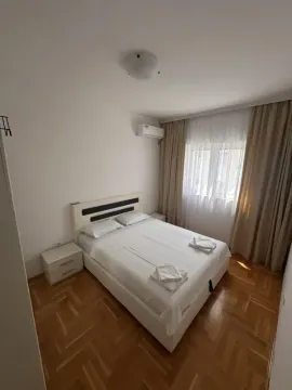 Bedroom with a double bed, bedside tables, and an air conditioner. - image 6