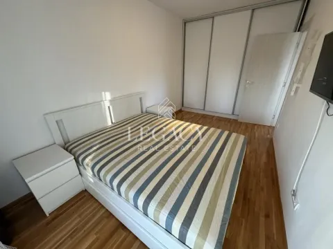 Nameštena spavaća soba sa bračnim krevetom, ormarom i drvenim podom. - image 4