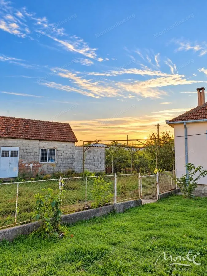 Pogled na dvorište i pomoćne objekte u sumrak.