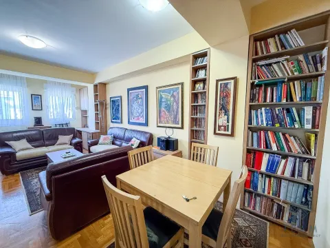 Living room with seating furniture, a dining table and a large bookshelf. - image 4