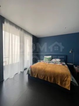 Modern bedroom with a double bed and a blue accent wall. - image 6