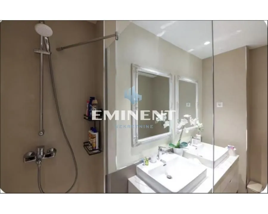 Modern bathroom with a shower cabin and double washbasin.