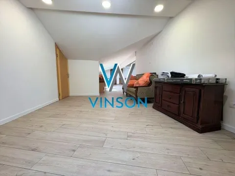 Living room with a sloping ceiling and a wooden chest of drawers. - image 2