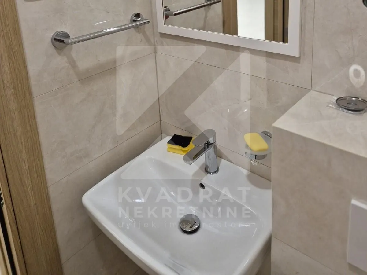Bathroom detail featuring a washbasin and a mirror.
