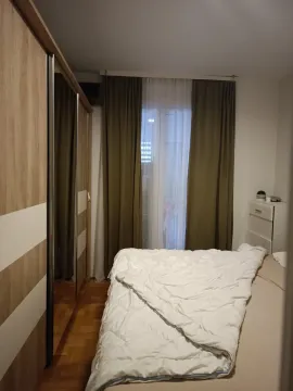 Namještena spavaća soba sa bračnim krevetom, garderoberom i balkonskim vratima. - image 5