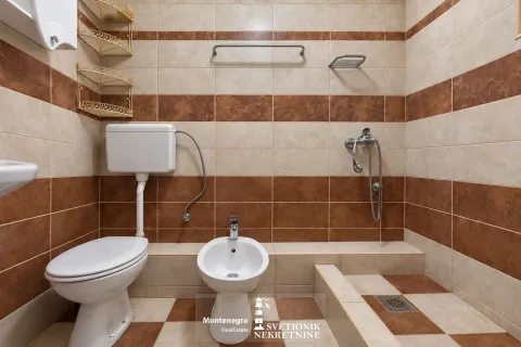 Kompaktno kupatilo sa WC šoljom, bideom i tuš kabinom obloženo keramičkim pločicama. - image 8