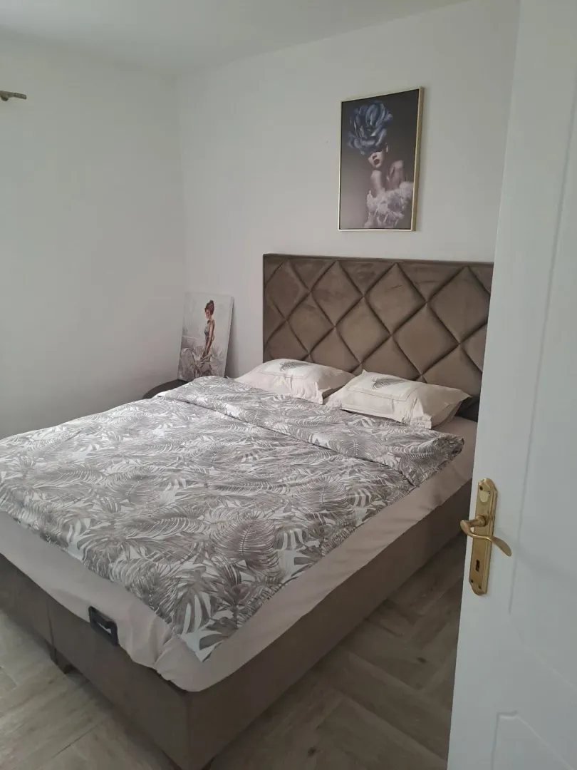 Furnished bedroom with a double bed and paintings on the wall.