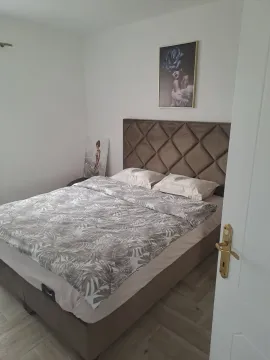 Furnished bedroom with a double bed and paintings on the wall. - image 3